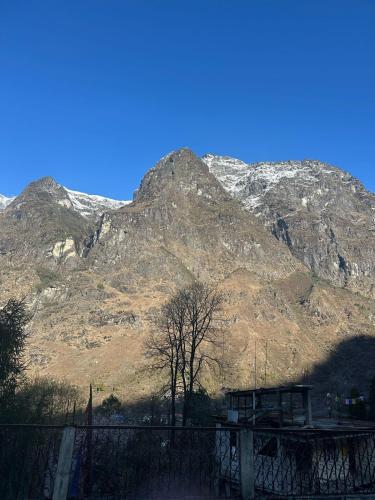 a mountain with snow capped mountains in the background at Cliff View Residency Lachung in Lachung