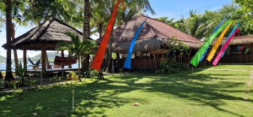 a group of colorful flags in front of a building at Castaway Surf Retreat in Sekongkang
