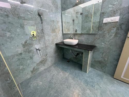 a bathroom with a sink and a mirror at Coramandal Heritage in Puducherry
