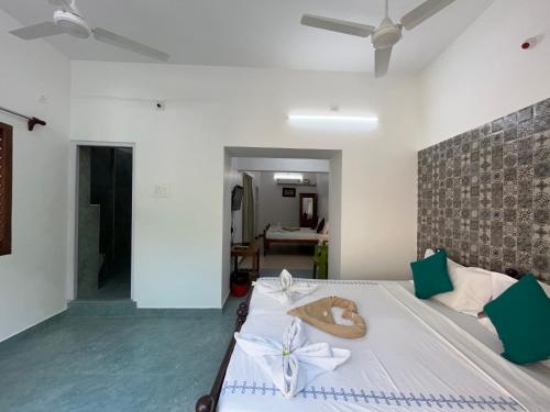 a bedroom with a bed with white bows on it at Coramandal Heritage in Puducherry
