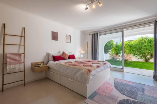 een slaapkamer met een bed en een groot raam bij Lemon House - 400m from the Beach - Wifi in Albufeira