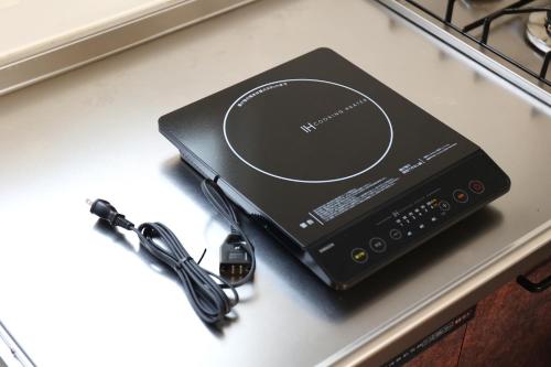 a laptop computer sitting on a counter with a charger at Ayumi STAY 駐車1台のみ in Sapporo