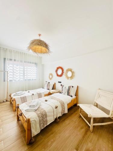 a room with three beds and a couch at Charmant Appartement 2 Room Wifi Marrakech in Marrakesh
