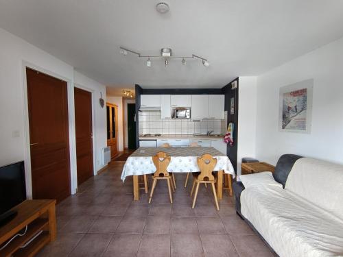 un salon avec une table, des chaises et un canapé dans l'établissement Appartement avec balcon plein sud, parking et animaux admis - FR-1-445-165, à Montgenèvre