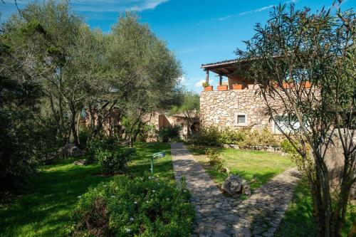 una vista esterna di una casa in pietra con alberi di Caletta Nest 11 a Porto Rotondo