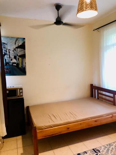 モンバサにあるStudio House Bandari Villas Mombasaの天井ファン付きの客室のベッド1台分です。