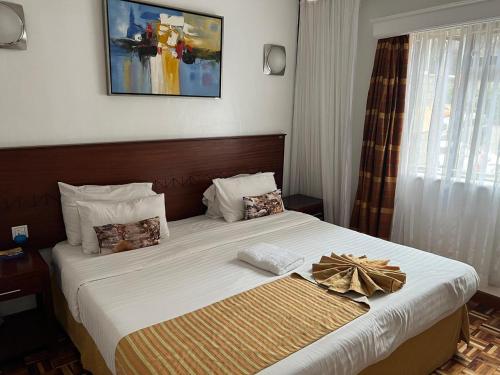 ein Hotelzimmer mit einem Bett mit einer Schleife darauf in der Unterkunft Lantana Suites in Nairobi