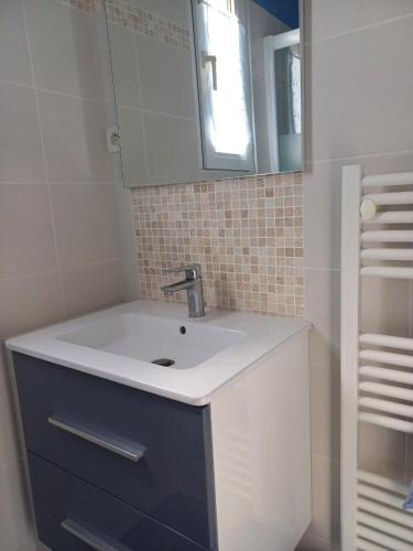 une salle de bain avec un lavabo et un miroir dans l'établissement Evasion à Meschers - Piscine - Plage - Tennis - Familles, à Meschers-sur-Gironde