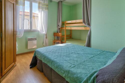 une chambre avec un lit et un lit superposé dans l'établissement MAISON AU CŒUR DU VILLAGE, à Saint-Nazaire-sur-Charente
