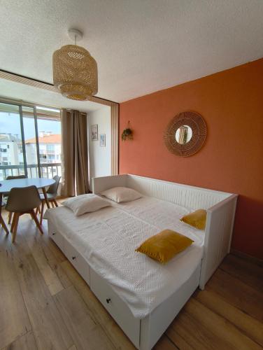 une chambre avec un lit blanc et une table dans l'établissement Chez Léna, au Grau-du-Roi