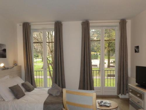 - une chambre avec un lit et un balcon avec des fenêtres dans l'établissement Studio cosy centre Aix-les-Bains avec wifi et animaux acceptés - FR-1-555-106, à Aix-les-Bains