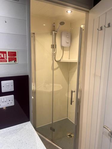 a shower with a glass door in a bathroom at Country Cabin in Hesket Newmarket