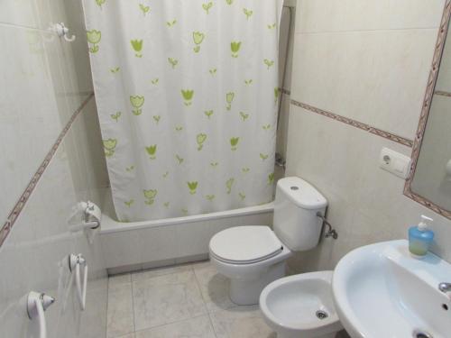 a bathroom with a toilet and a shower curtain at Duerming Bolera Pico in Portonovo