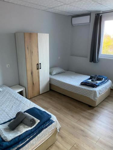 a bedroom with two beds and a window at Стаи за гости Крис in Vratsa