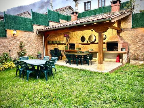 a patio with tables and chairs in a yard at Viviendas Rurales El Cantón in Cucayo