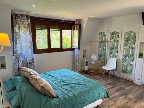 une chambre avec un lit, une fenêtre et une chaise dans l'établissement Le Jonquet maison 12 pers Sauna Jacuzzi, à Douriez