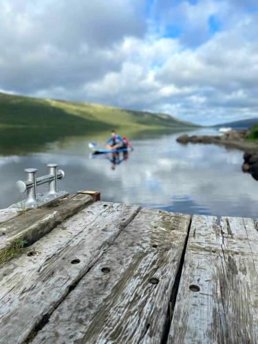 two people on a boat on a river at Lakefront cottage with jacuzzi in Borgarnes