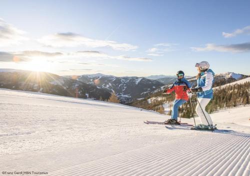 two people on skis standing on a ski slope at Chalet Bergblick Suites - Luxury Escape in Bad Kleinkirchheim