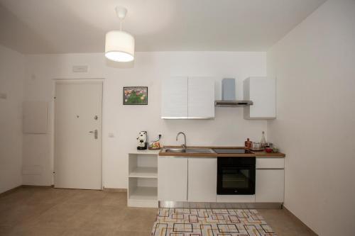 a kitchen with white cabinets and a sink at Case vacanze Taiji in Cassino