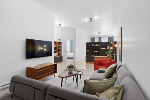a living room with a couch and a tv at New Modern 2bdr Apartment in Little Italy in Montréal