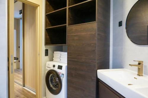 a bathroom with a washing machine and a sink at MT Suites ApartHotel in Budapest
