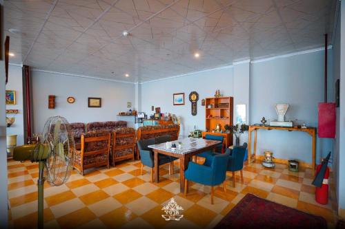 a living room with a table and blue chairs at Vote Hotel 2 in Erbil