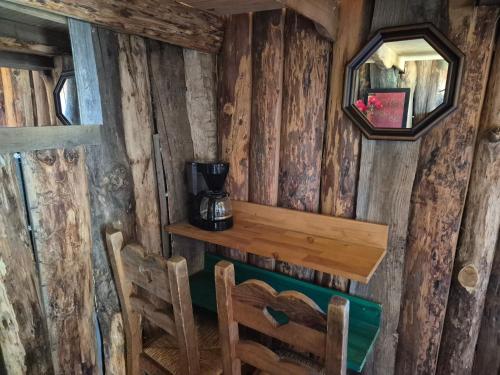 Cette chambre est dotée de murs en bois, d'une table et de chaises. dans l'établissement Cabane insolite, à Saint-Germain-de-Calberte