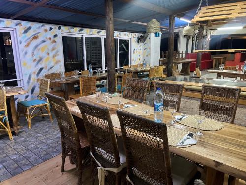 a large wooden table with chairs and a bottle of water at Happy Destination Auberge in La Ferme