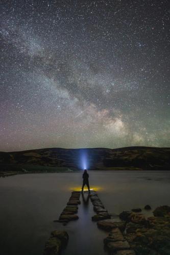 a person standing on a walkway under a starry sky at Craggan in Ballater