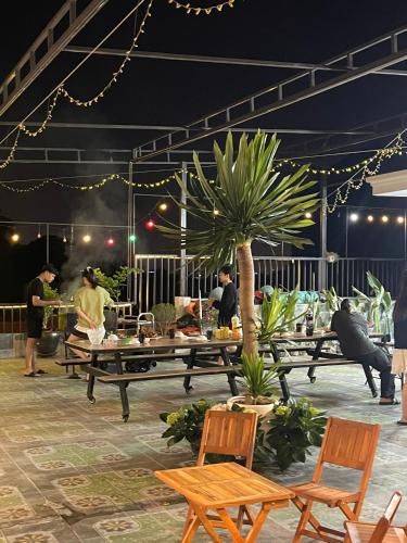 a group of people standing around a patio with a table at Hang Múa Green Mountain View House in Ninh Binh
