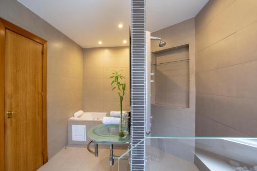 a bathroom with a glass table and a bath tub at Sunstay Chalet La Colina Torremolinos in Torremolinos