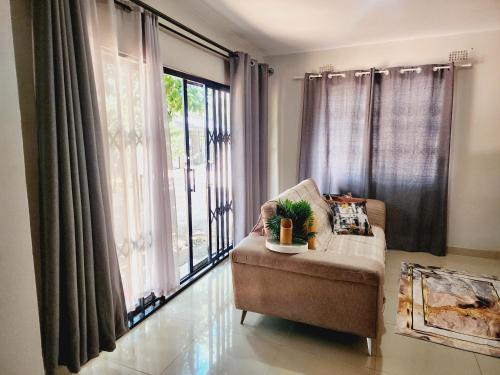 a living room with a chair and a large window at Eastern Road Executive Suites in Harare