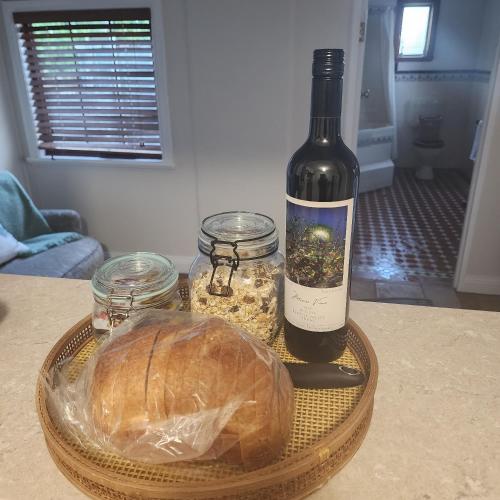 a bottle of wine and a loaf of bread on a table at Telegraph Cottage in Greenock