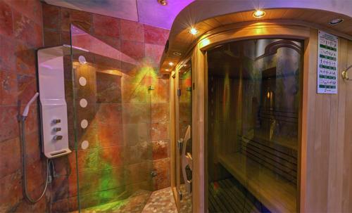 a bathroom with a walk in shower next to a wall at NaturMed Hotel am Park in Badenweiler