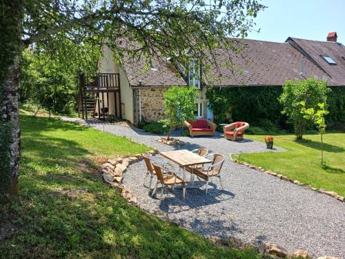 a patio with a table and chairs in front of a house at Gîte Montgaudon in Préporché