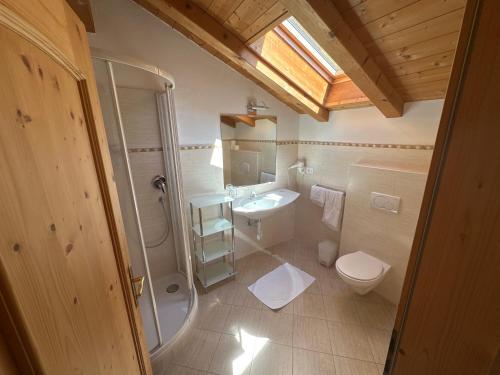 a bathroom with a toilet and a sink and a shower at Hotel Rastlhof in Schenna