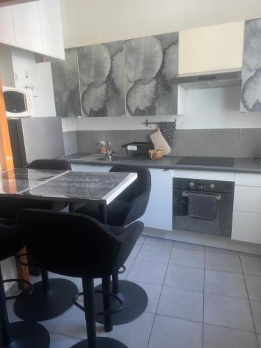 - une cuisine avec une table et des chaises noires dans l'établissement Appartement quartier la Timone, à Marseille
