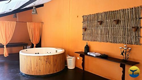 a bathroom with a large tub and orange walls at Hotel Cumuruxatiba in Cumuruxatiba