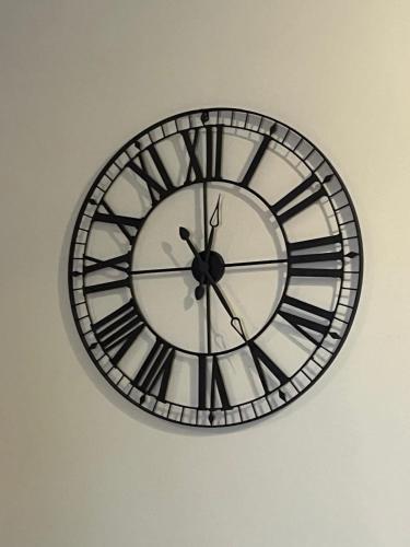 a black and white clock on a wall at Susannah's Place in Żejtun