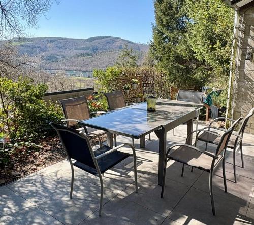 a table and chairs on a patio with a view at Vieux Sart 34, chez Dame Béa in Stavelot