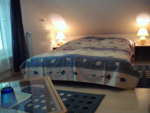 a bed in a bedroom with a table with a keyboard at Apart Hévízi Ház in Hévíz