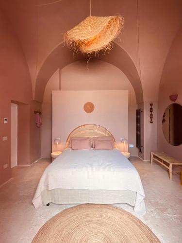 a bedroom with a large bed and a large chandelier at Antica Masseria le Monache in Grottaglie