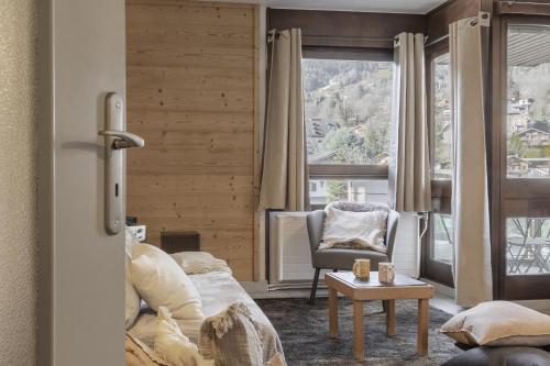 a living room with a couch and a table at Le Castel des Roches - Sejour ski & spa in Saint-Gervais-les-Bains