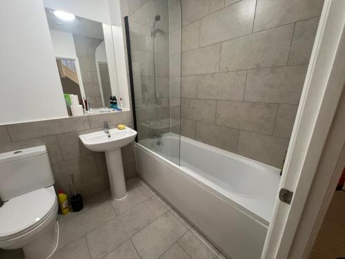 a bathroom with a toilet and a sink and a shower at Cosy double room in Canada Water in London