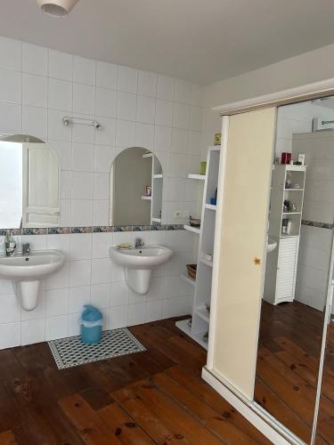 une salle de bain avec deux lavabos et deux miroirs dans l'établissement Maison triplex centre de Lourdes, à Lourdes