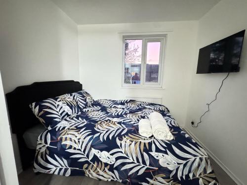a bed with a blue and white comforter in a room at Cosy Retreat in Greenwich