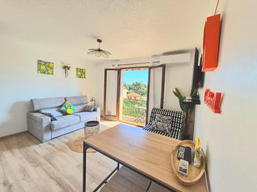 un salon avec une table et un canapé dans l'établissement Studio Limonista - cœur Saint Aygulf, à Saint-Aygulf