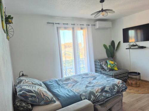 un salon avec un lit et une fenêtre dans l'établissement Studio Limonista - cœur Saint Aygulf, à Saint-Aygulf