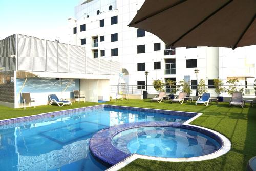 a swimming pool on the side of a building at Grandeur Hotel Al Barsha in Dubai