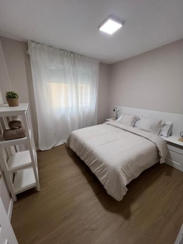 a white bedroom with a bed and a window at mar in Moaña